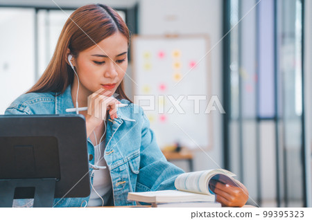 young student wearing small talk studies online, distance learning, and keeps up to date on the global coronavirus pandemic 99395323