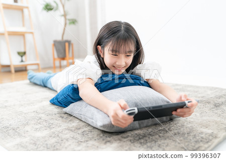 girl lying down and playing games girl lying down and playing games 99396307