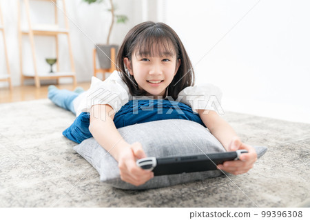 girl lying down and playing games girl lying down and playing games 99396308
