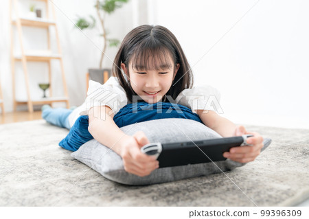 girl lying down and playing games girl lying down and playing games 99396309