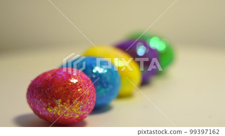 Colorful Easter eggs rotating in rows in a seamless loop on a light background Colorful Easter eggs rotating in rows in a seamless loop on a light background 99397162