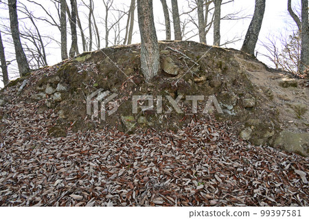 The enclosure and stone walls of Komayama Castle in Harima overlooking the city of Kamigori 99397581