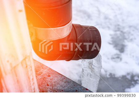 frozen water in downspout gutter of the roof drainage system with ice 99399830