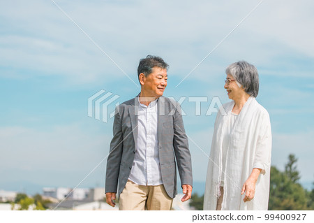 Japanese elderly couple walking while talking on the street (senior man and woman) 99400927