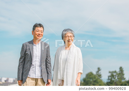 Japanese elderly couple walking while talking on the street (senior man and woman) Japanese elderly couple walking while talking on the street (senior man and woman) 99400928