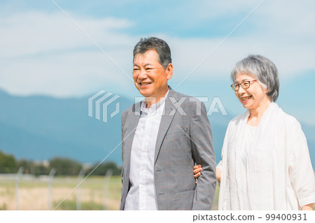 Japanese elderly couple walking while talking on the street (senior man and woman) 99400931