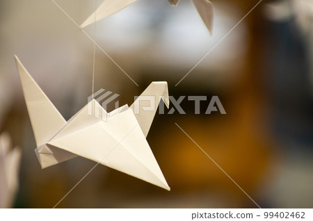 Japanese folded Origami cranes hanging on with strings. Hundreds handmade paper birds isolated with copy space. 1000 thousand crane sculpture topic. Symbol of peace, faith, health, wishes, hope Japanese folded Origami cranes hanging on with strings. Hundreds handmade paper birds isolated with copy space. 1000 thousand crane sculpture topic. Symbol of peace, faith, health, wishes, hope 99402462