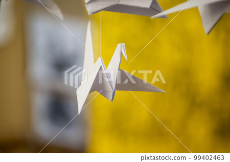 Japanese folded Origami cranes hanging on with strings. Hundreds handmade paper birds isolated with copy space. 1000 thousand crane sculpture topic. Symbol of peace, faith, health, wishes, hope 99402463