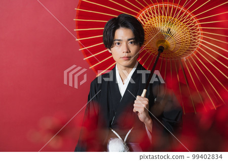 一個穿著帶徽章的袴的男人,一把日本傘 一個穿著帶徽章的袴的男人,一把日本傘 99402834