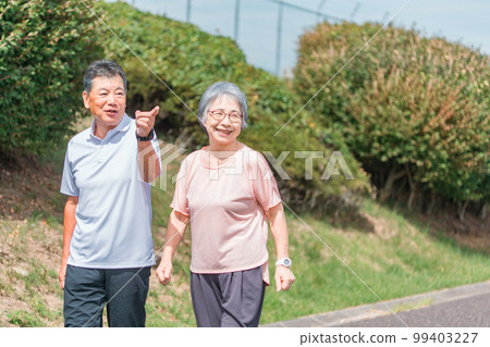 Elderly couple (senior, male and female) walking and aerobic exercise in the park 99403227