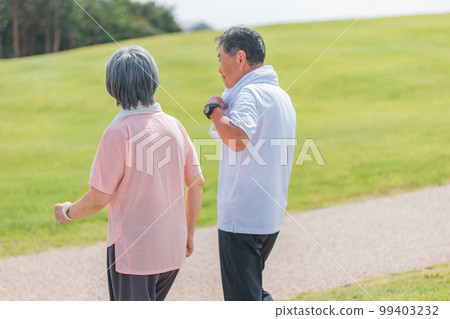 一對老年夫婦在公園散步和有氧運動的後視圖(老年、男性和女性) 一對老年夫婦在公園散步和有氧運動的後視圖(老年、男性和女性) 99403232