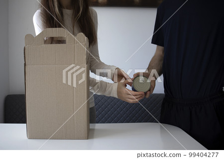 Unpacking a week's worth of food. A woman and a man are unpacking boxes of groceries. 99404277