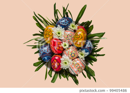 Easter eggs and spring flower on green grass on the plate on isolated background top view 99405486
