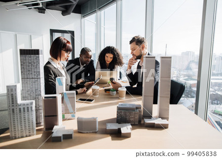 Business team of four good-looking multiethnic corporate workers discussing financial report 99405838