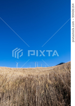 Scenery of wind power generation in the wind blowing in Aso in the white clouds and blue sky Scenery of wind power generation in the wind blowing in Aso in the white clouds and blue sky 99406164