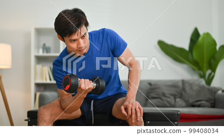 Sporty young man sitting on sports bench and lifting dumbbells. Fitness, weightlifting and bodybuilding concept Sporty young man sitting on sports bench and lifting dumbbells. Fitness, weightlifting and bodybuilding concept 99408034