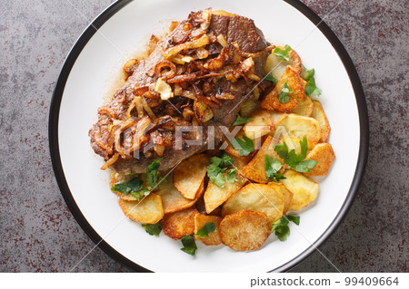 Original and Authentic German Zwiebelrostbraten with onion gravy and fried potatoes Bratkartoffeln closeup on the plate. Horizontal top view Original and Authentic German Zwiebelrostbraten with onion gravy and fried potatoes Bratkartoffeln closeup on the plate. Horizontal top view 99409664