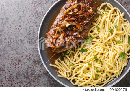 Zwiebelrostbraten Swabian Beef Roast with fried onions and spaetzle closeup on the plate. Horizontal top view Zwiebelrostbraten Swabian Beef Roast with fried onions and spaetzle closeup on the plate. Horizontal top view 99409676