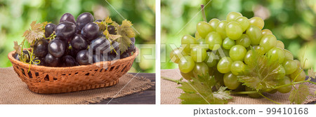Blue grapes in a wicker basket on wooden table with blurred background 99410168