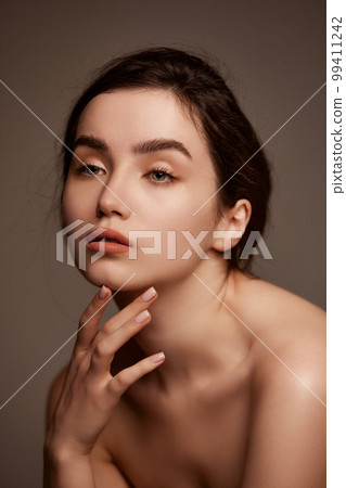 Natural makeup and healthy skin, wellness. Portrait of young beautiful girl with brown hair posing over dark grey studio background. Concept of natural beauty, skin care, cosmetology Natural makeup and healthy skin, wellness. Portrait of young beautiful girl with brown hair posing over dark grey studio background. Concept of natural beauty, skin care, cosmetology 99411242