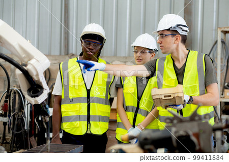 Team engineer man and woman talking and explaining about robot arms technology intelligence. Team engineer man and woman talking and explaining about robot arms technology intelligence. 99411884