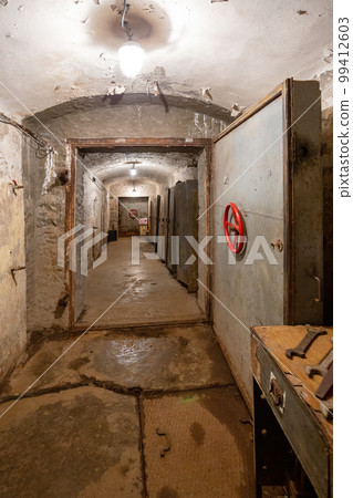 Hermetic rusty door of the bunker in underground abandoned tunnel. Mysterious old iron gate. Secret entrance Hermetic rusty door of the bunker in underground abandoned tunnel. Mysterious old iron gate. Secret entrance 99412603