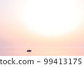 Sunset at sea. Romantic photo with the sea rolling in the sky and the couple in love in a boat. Pink sunset, big sun, bright lights, waves, black silhouette of people in a boat. Copy space 99413175