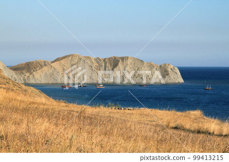 Seascape. Rocks, sea, sun, boats on a sunny day. Holidays at sea. landscape with boats and calm sea. Photo of a southern city without people. Tourism, advertising, summer 99413215