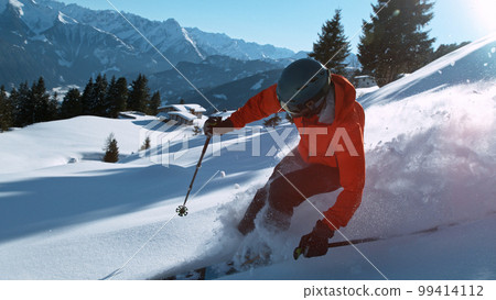 Freeride skier riding in the scenic mountains with blue sky 99414112