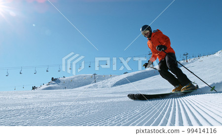 Freeride skier riding in the scenic mountains with blue sky 99414116