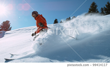 Freeride skier riding in the scenic mountains with blue sky 99414117