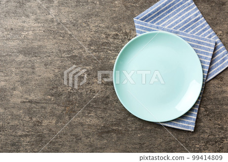 Top view on colored background empty round green plate on tablecloth for food. Empty dish on napkin with space for your design 99414809
