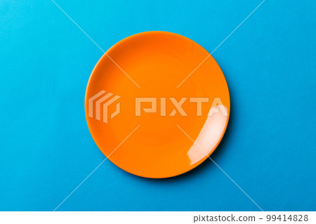 Top view of isolated of colored background empty round orange plate for food. Empty dish with space for your design 99414828