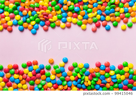 Mixed collection of colorful candy, on colored background. Flat lay, top view. frame of colorful chocolate coated candy Mixed collection of colorful candy, on colored background. Flat lay, top view. frame of colorful chocolate coated candy 99415046