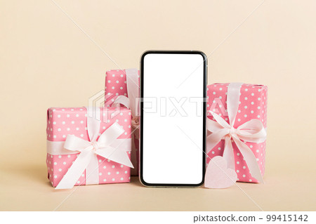 mobile phone with blank screen on colored background with hearts, calendar and gift box, valentine day concept perspertive view flat lay mobile phone with blank screen on colored background with hearts, calendar and gift box, valentine day concept perspertive view flat lay 99415142