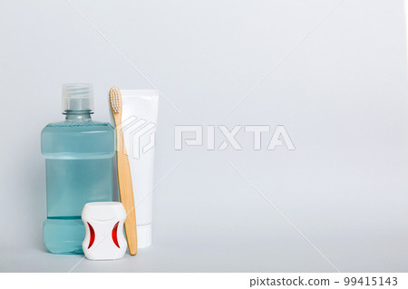Mouthwash and other oral hygiene products on colored table top view with copy space. Flat lay. Dental hygiene. Oral care products and space for text on light background. concept 99415143