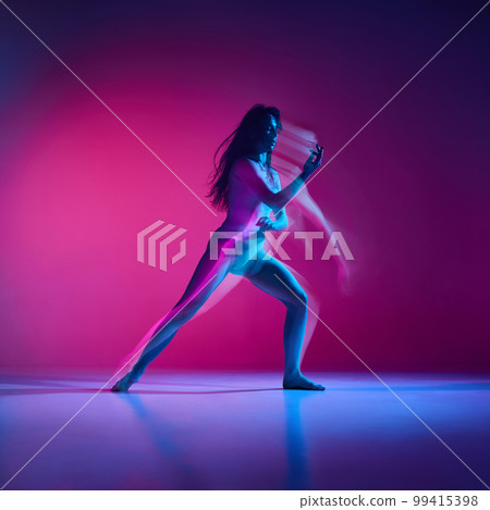 Feelings. Young woman dancing modern dance style over gradient pink studio background in neon with mixed lights. Concept of dance aesthetics, art 99415398