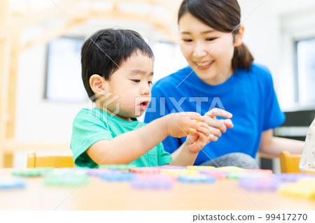 Toddler studying with alphabet puzzle Toddler studying with alphabet puzzle 99417270