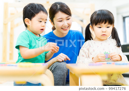 Toddler studying with alphabet puzzle Toddler studying with alphabet puzzle 99417276