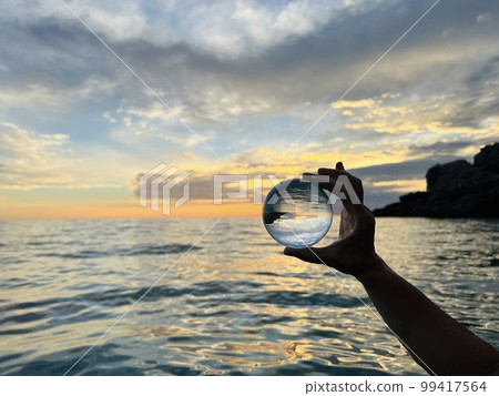 Beautiful scenic view through lens of crystal ball at summer sunset.  99417564