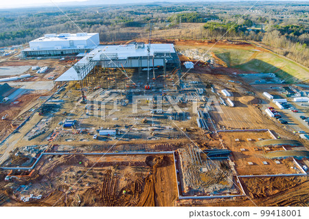 During construction an industrial warehouse on construction site, crawler cranes are used as part construction process. 99418001