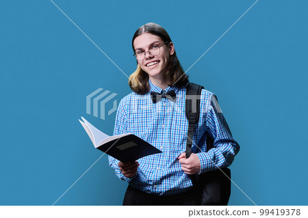 Portrait of young male college student, with notebook in hands on blue background 99419378