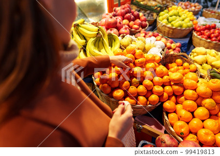 Close up of a woman choosing fruits and vegetables at farmers market Close up of a woman choosing fruits and vegetables at farmers market 99419813