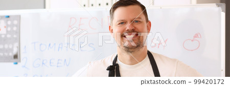 Smiling male chef in apron conducts online cooking training and recipes for delicious dishes Smiling male chef in apron conducts online cooking training and recipes for delicious dishes 99420172