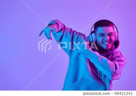 man with headphones in sweatshirt enjoying favorite music man with headphones in sweatshirt enjoying favorite music 99421341