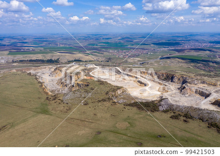 Aerial drone view of a limestone quarry, open pit mine Aerial drone view of a limestone quarry, open pit mine 99421503