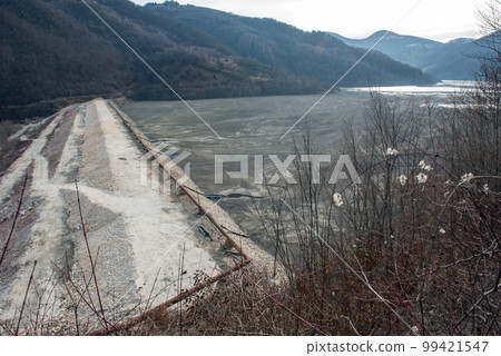 Barrier stopping the flow of copper and gold mining mining residuals into a settling basin, decantation lake Barrier stopping the flow of copper and gold mining mining residuals into a settling basin, decantation lake 99421547