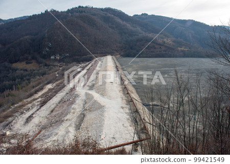 Barrier stopping the flow of copper and gold mining mining residuals into a settling basin, decantation lake Barrier stopping the flow of copper and gold mining mining residuals into a settling basin, decantation lake 99421549
