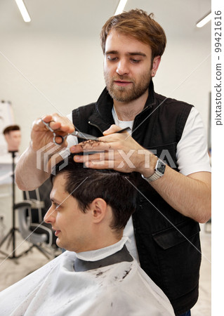 hairdresser does haircut for caucasian bearded man hairdresser does haircut for caucasian bearded man 99421616