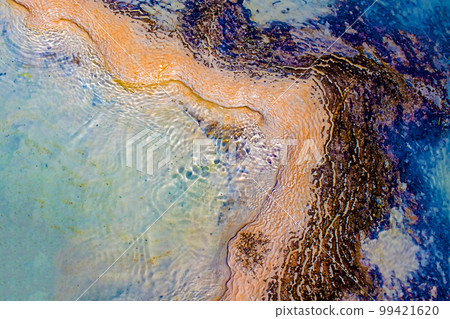 View of natural terraces in Pamukkale on a summer day. Close-up texture of limestone and water flowing over it. 99421620